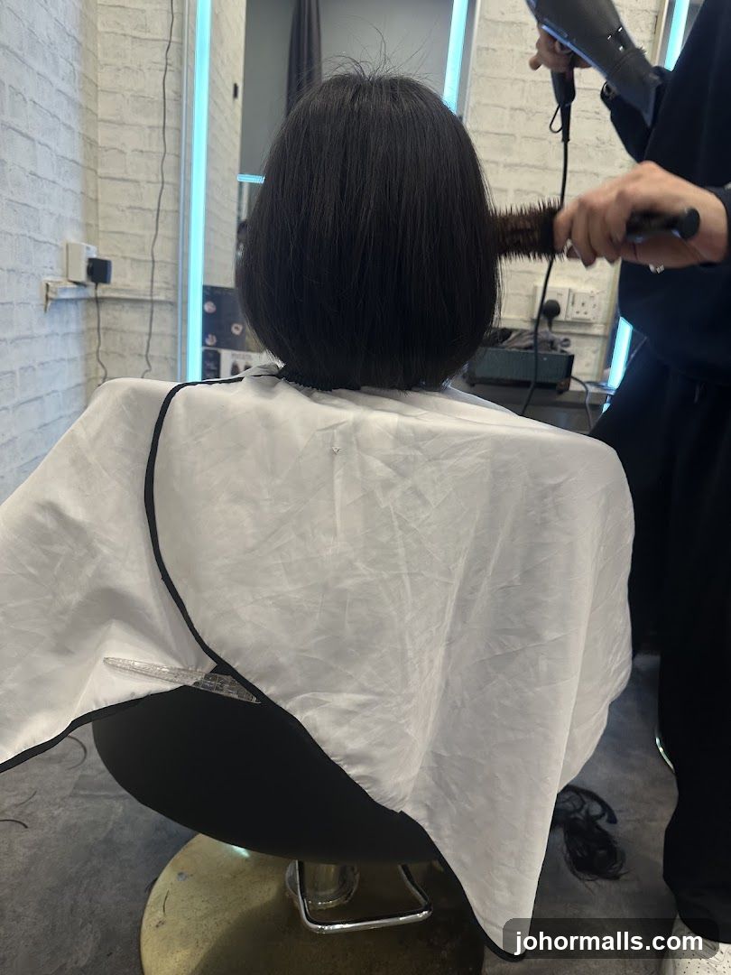 Hairdresser drying client's hair