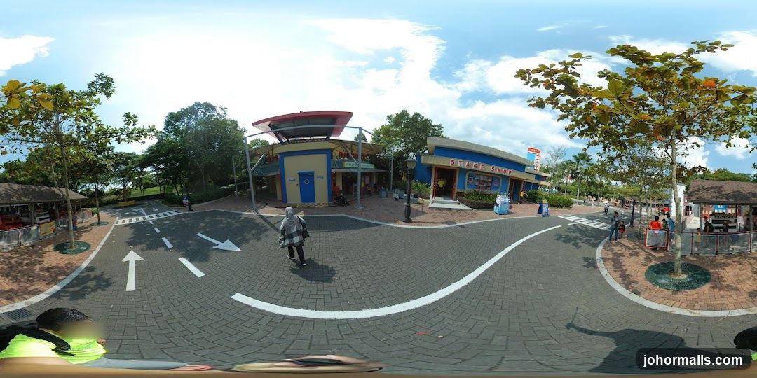Outdoor street scene with shops and trees