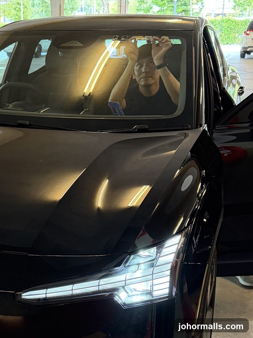 Man installing device on car windshield