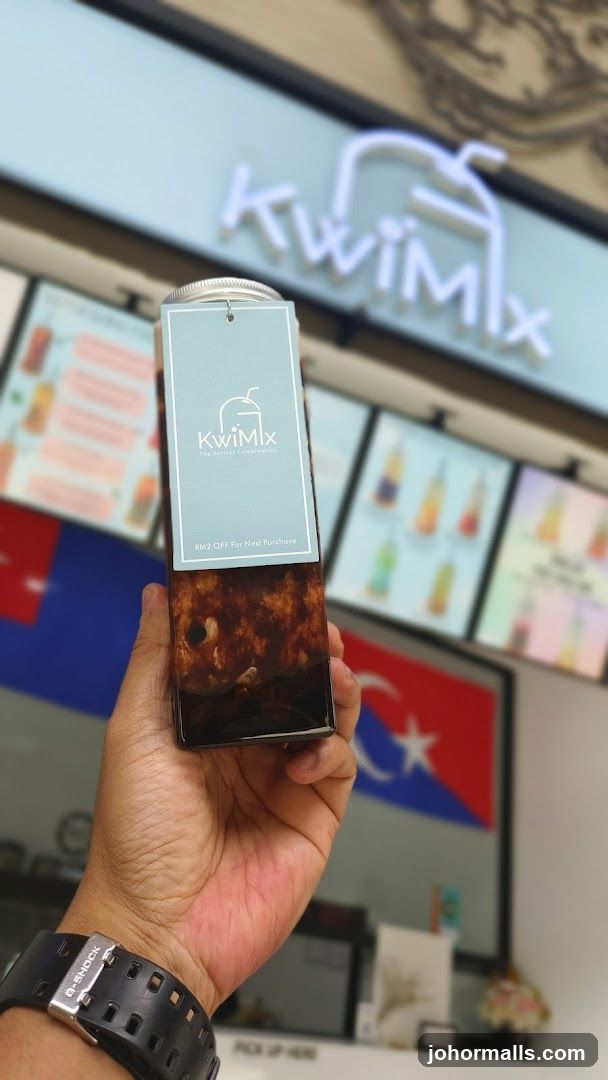 Hand holding a drink with store logo in background