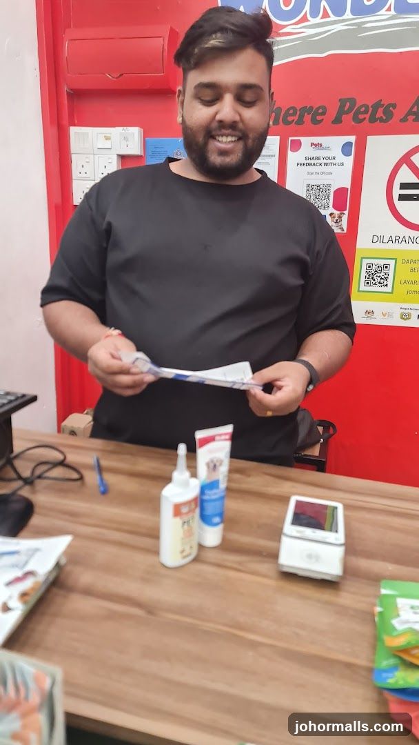Man holding a receipt at a pet store counter