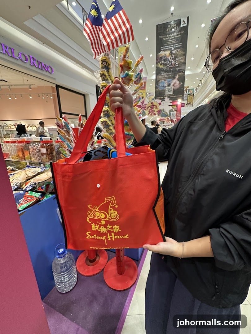 Person holding a red tote bag with a logo