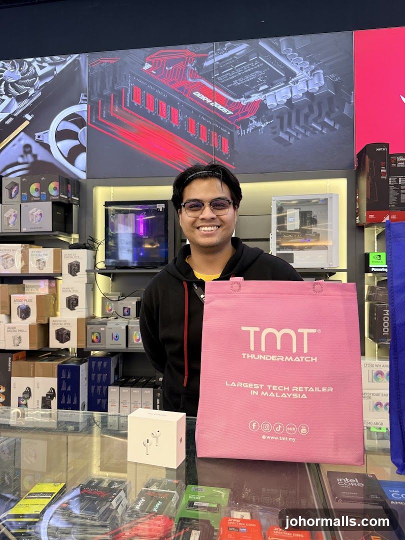 Man holding a TMT bag in a tech store