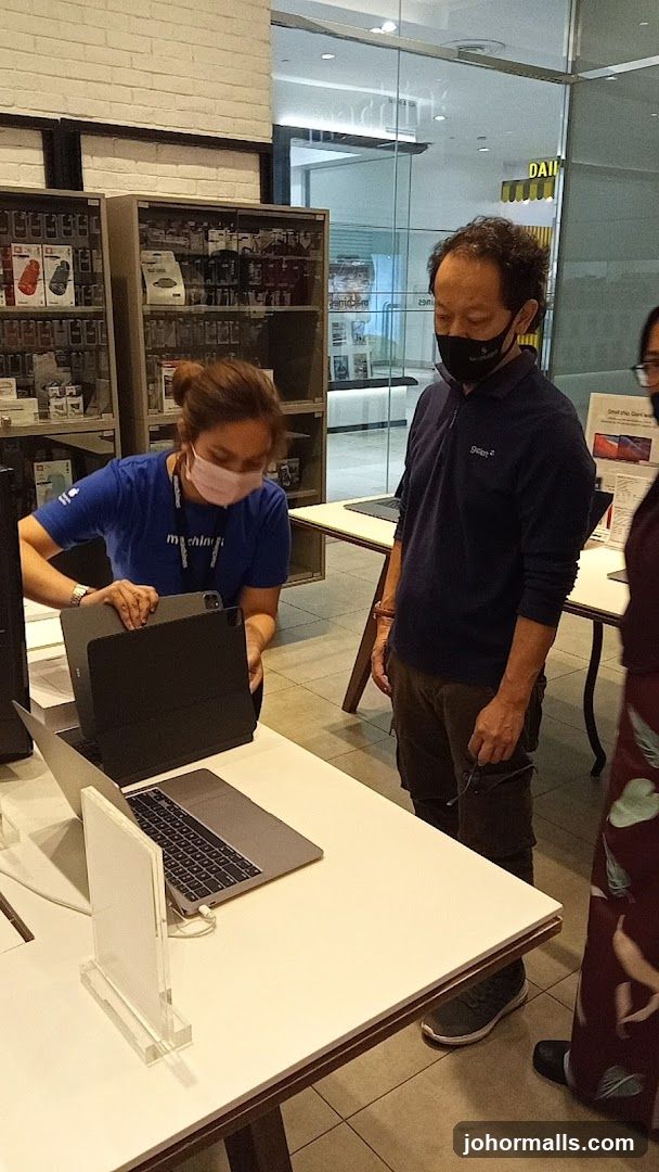 Salesperson assisting customer with a laptop
