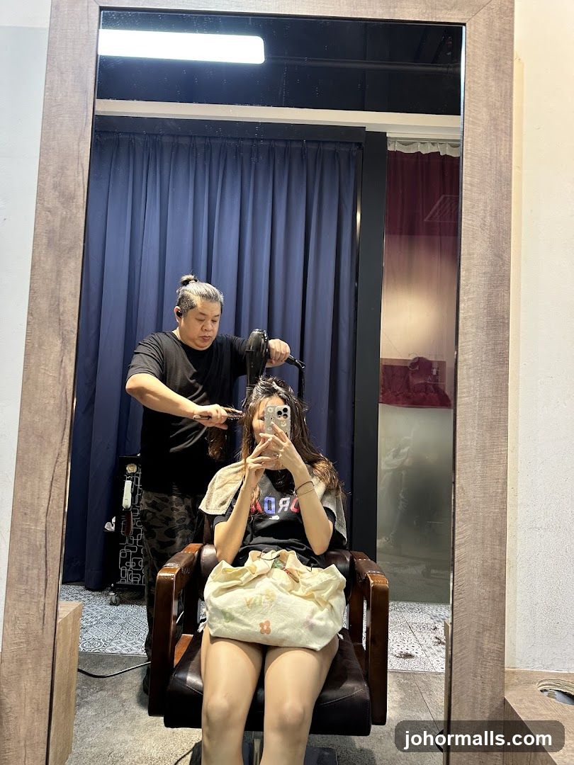 Hairdresser drying client's hair