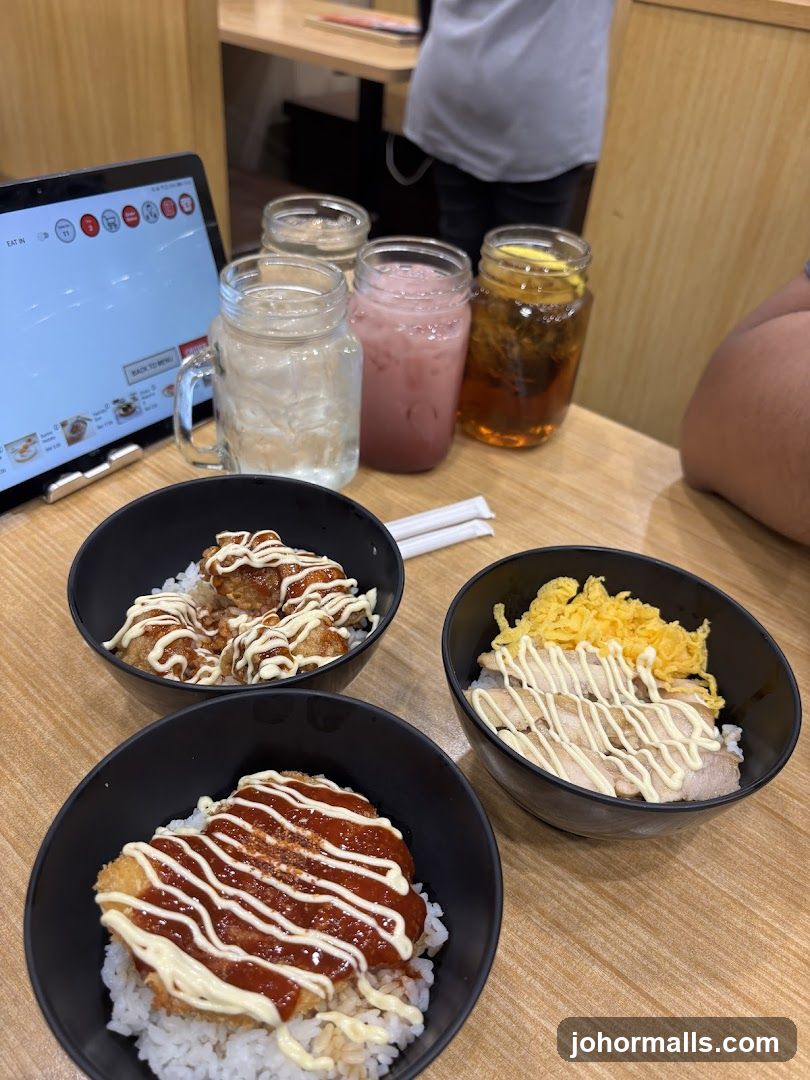 Three bowls of rice with toppings and drinks