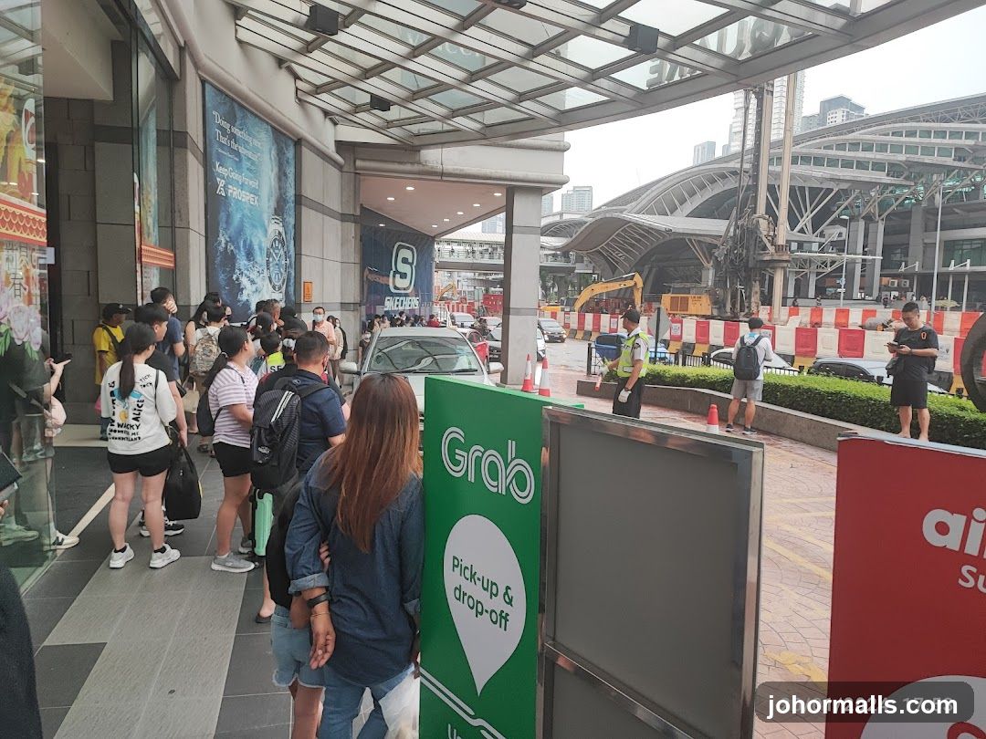 People waiting outside a building with advertisements