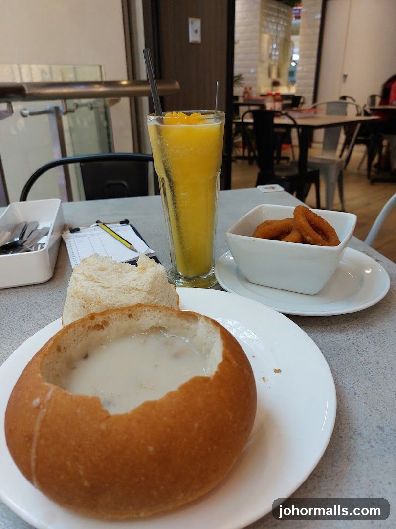 Soup in a Bread Bowl with Onion Rings and Orange Drink