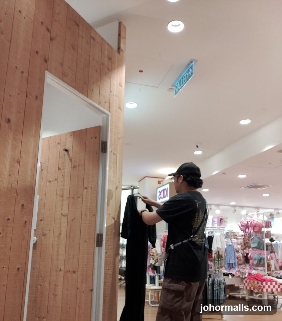 Man holding a black dress in a store
