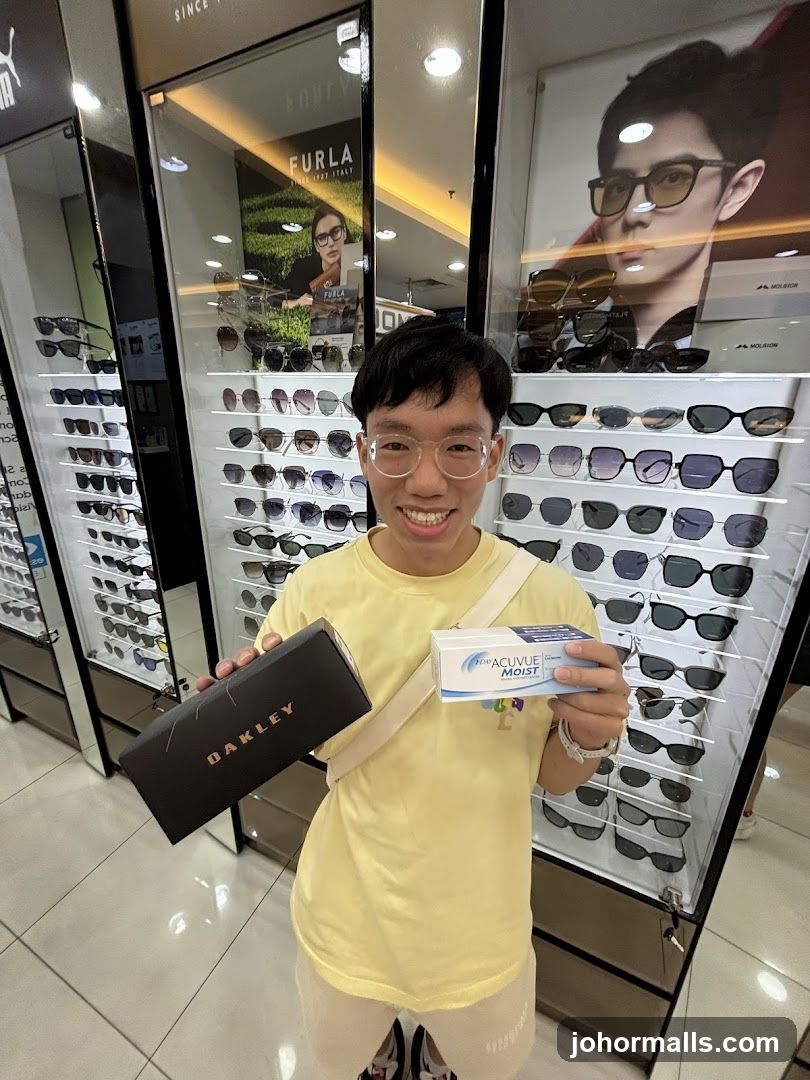 Man holding Oakley box and Acuvue contact lens box in optical store