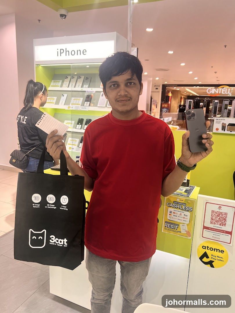 Man holding an iPhone and a shopping bag