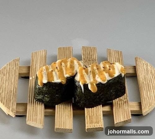 Two pieces of sushi with sauce