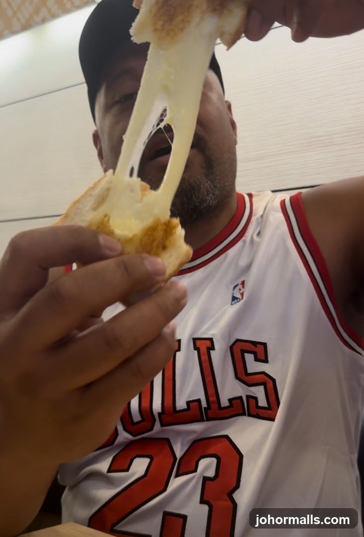 Man holding a cheese-filled sandwich