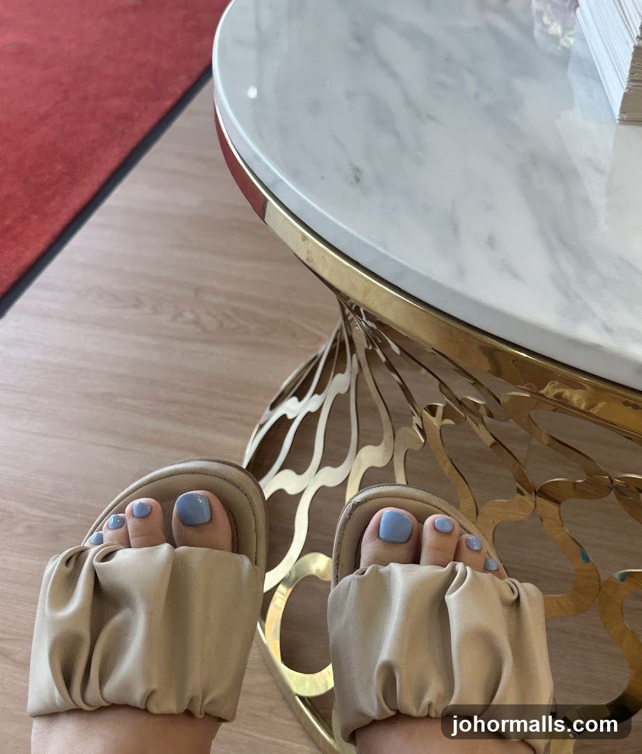 Feet with blue nail polish and beige sandals