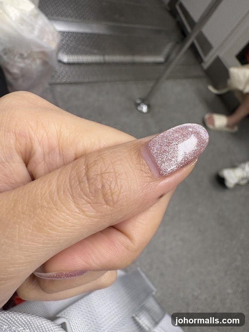Close-up of a person's hand with glittery pink nails