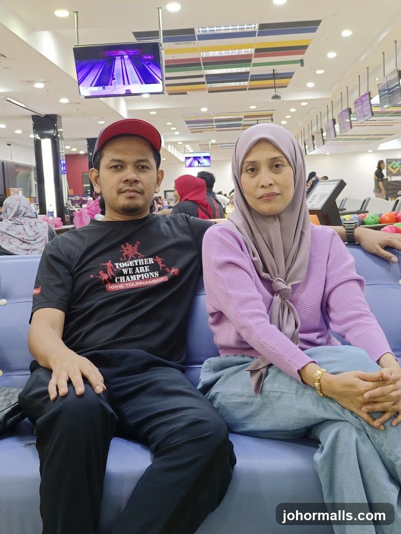 People sitting on a couch in a bowling alley