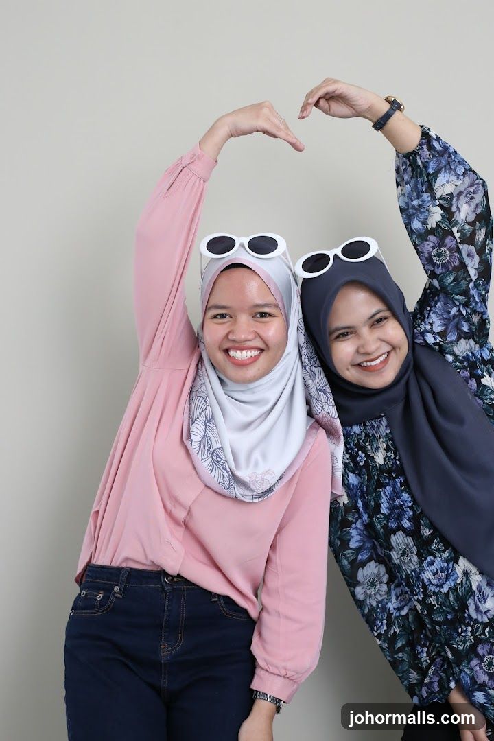 Two women making a heart shape with their hands