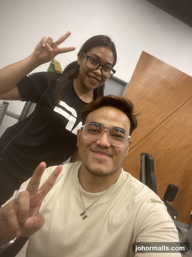 Two people posing for a selfie in a gym