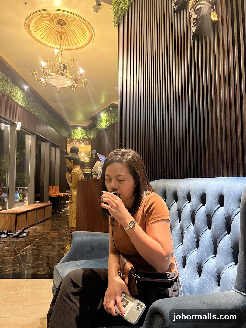 Woman drinking from a cup in a lounge
