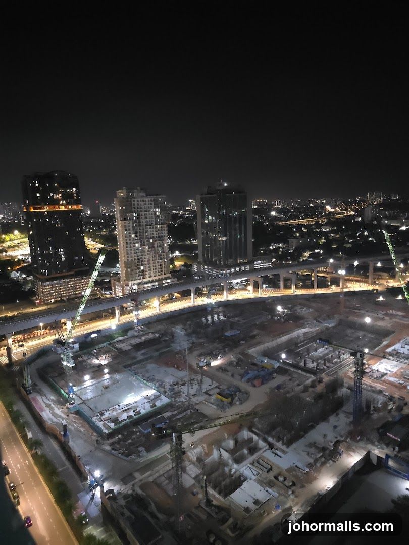 Nighttime construction site with city skyline