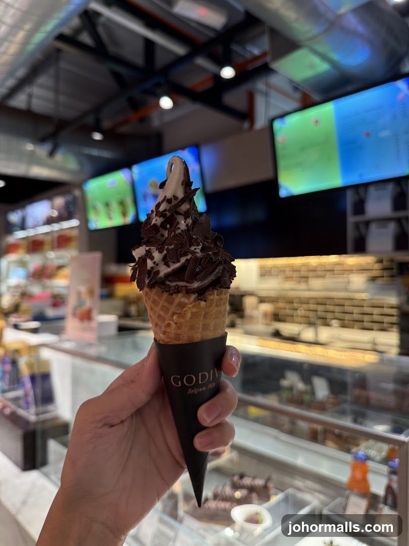 Hand holding a Godiva ice cream cone