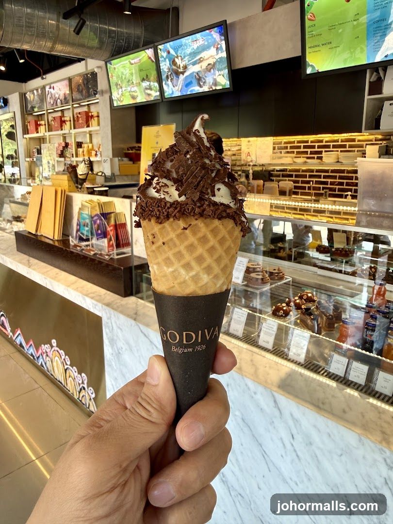 Hand holding a Godiva ice cream cone