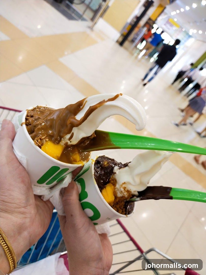 Two cups of frozen yogurt with toppings