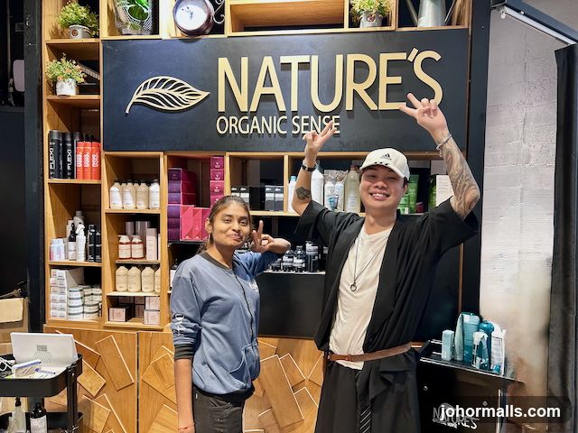 Two people in front of shelves stocked with hair products