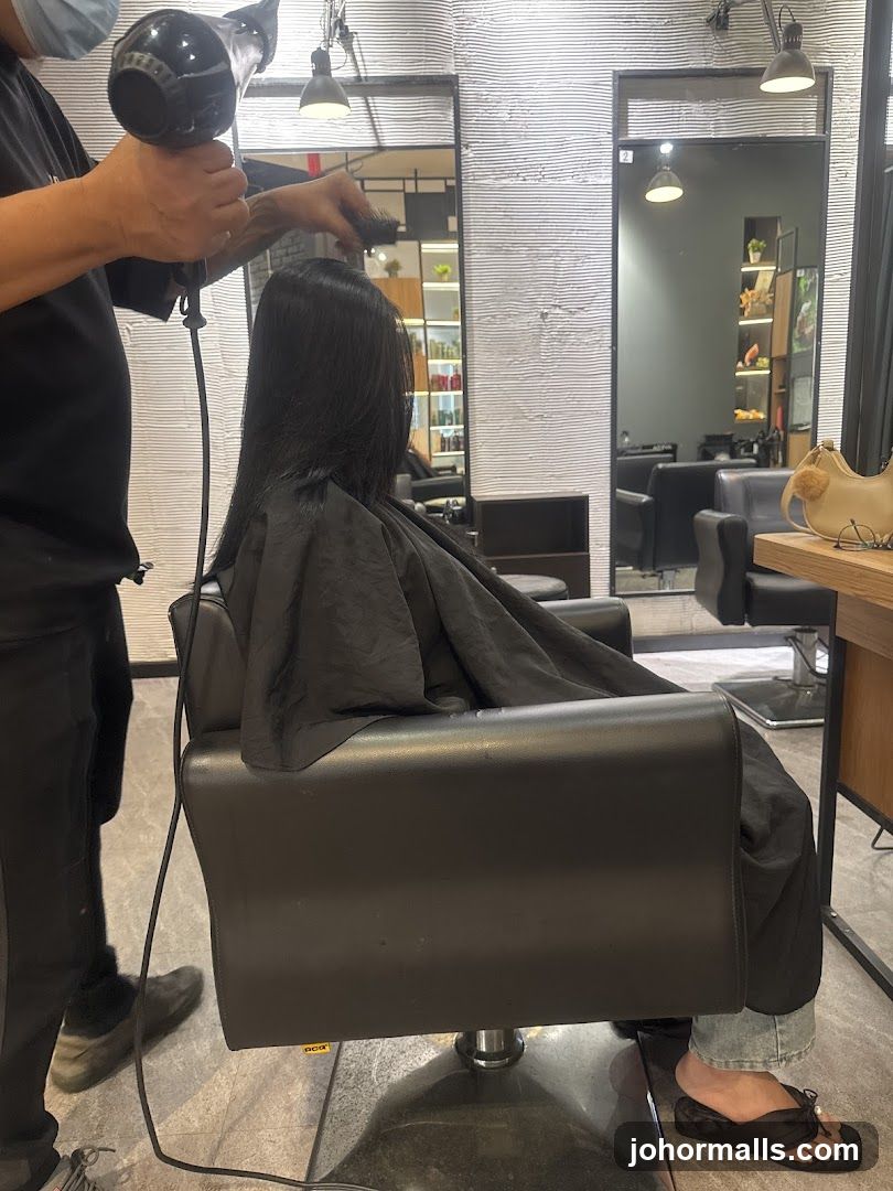 Hairdresser drying client's hair