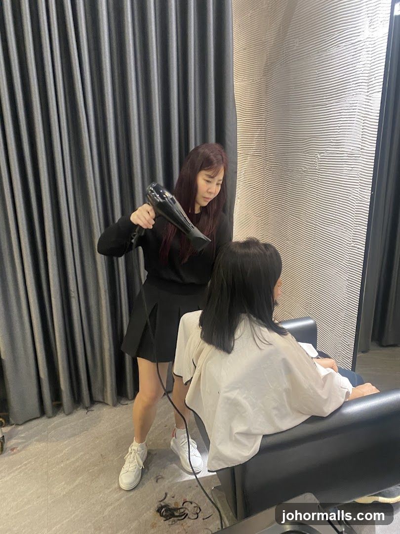 Hairdresser drying client's hair