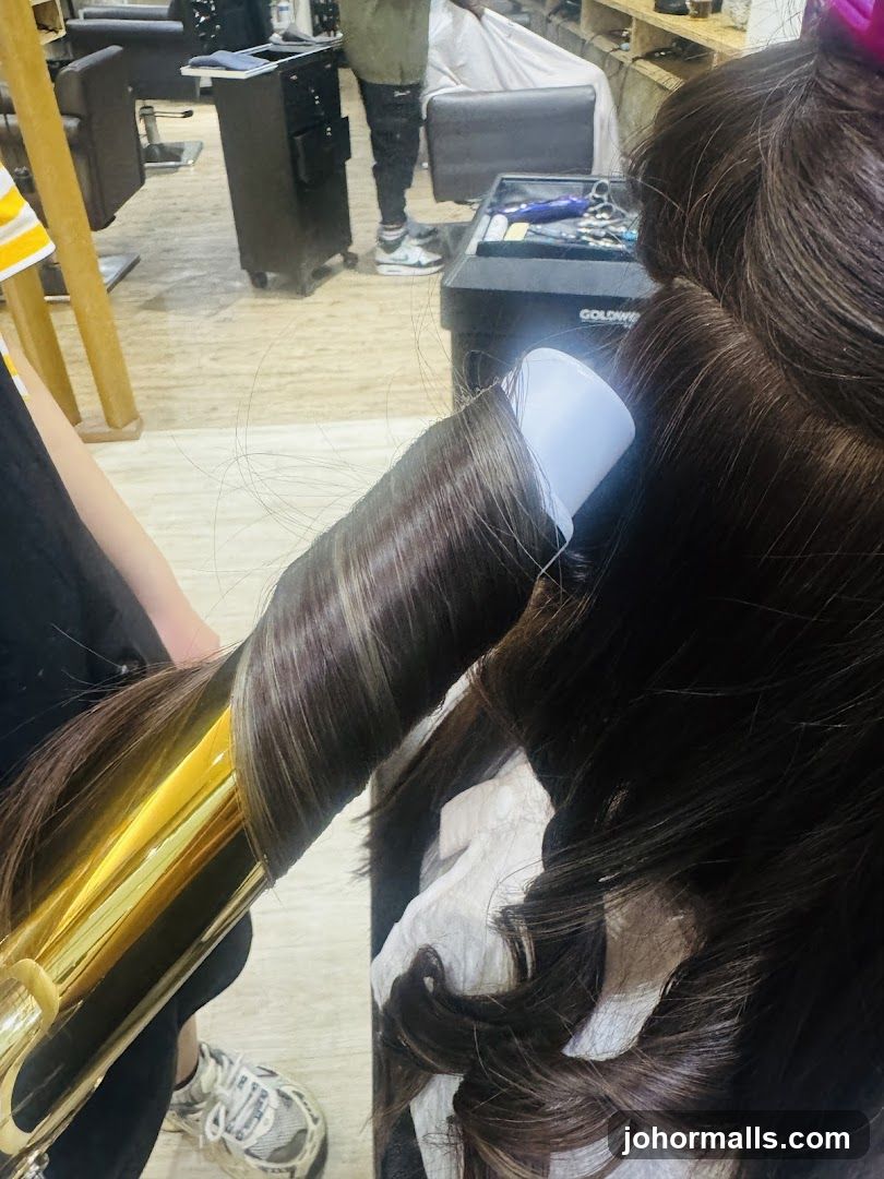 Hairdresser curling client's hair