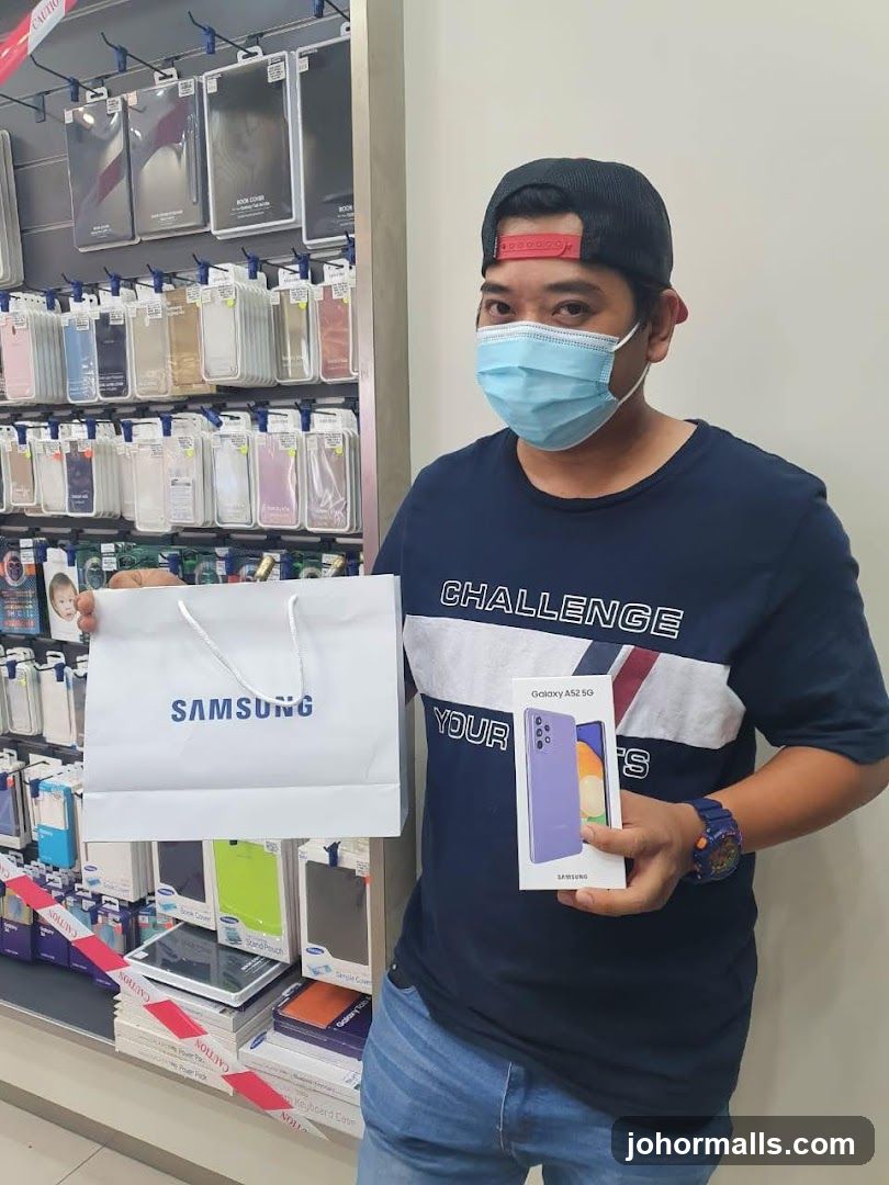 Man holding Samsung shopping bag and phone box