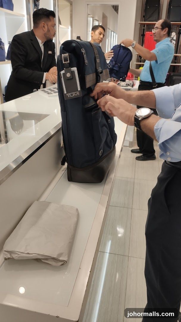 Customers examining a Tumi backpack