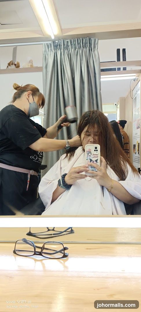 Hairdresser drying client's hair