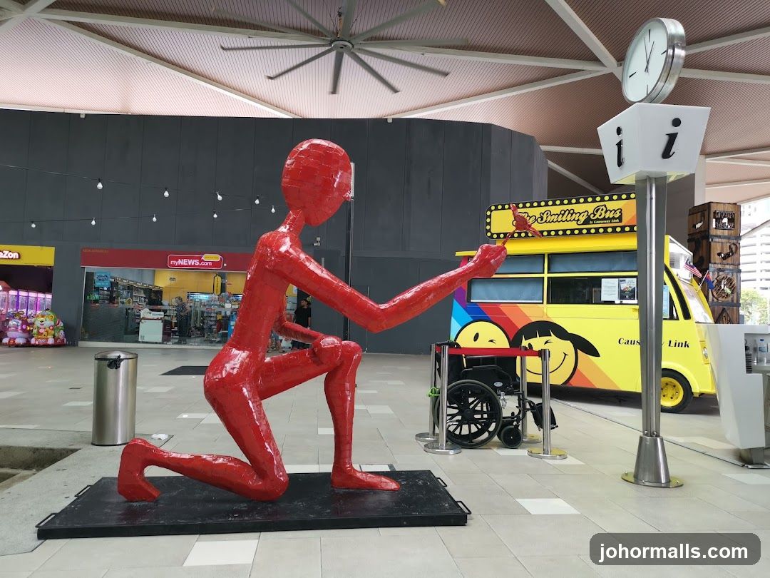 Red Sculpture and Smiling Bus
