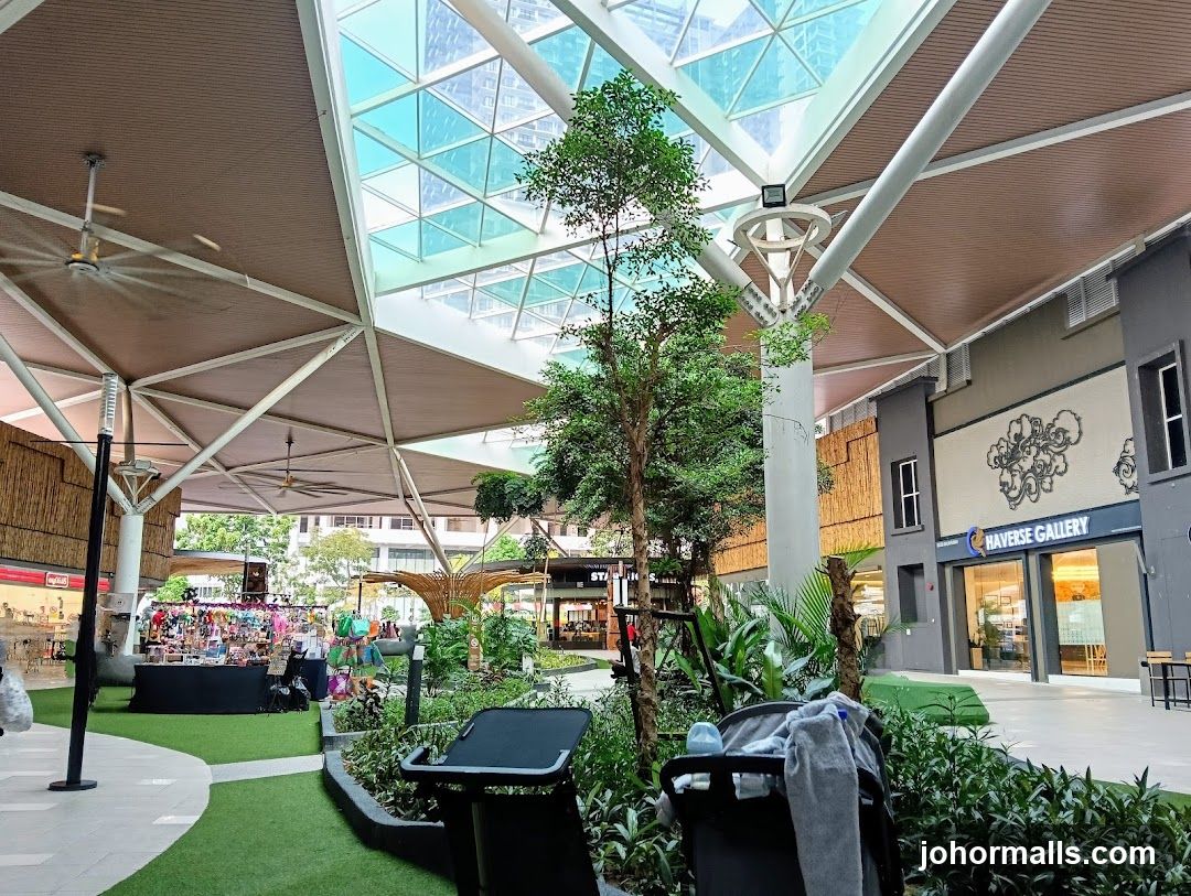 Indoor shopping area with greenery and stalls