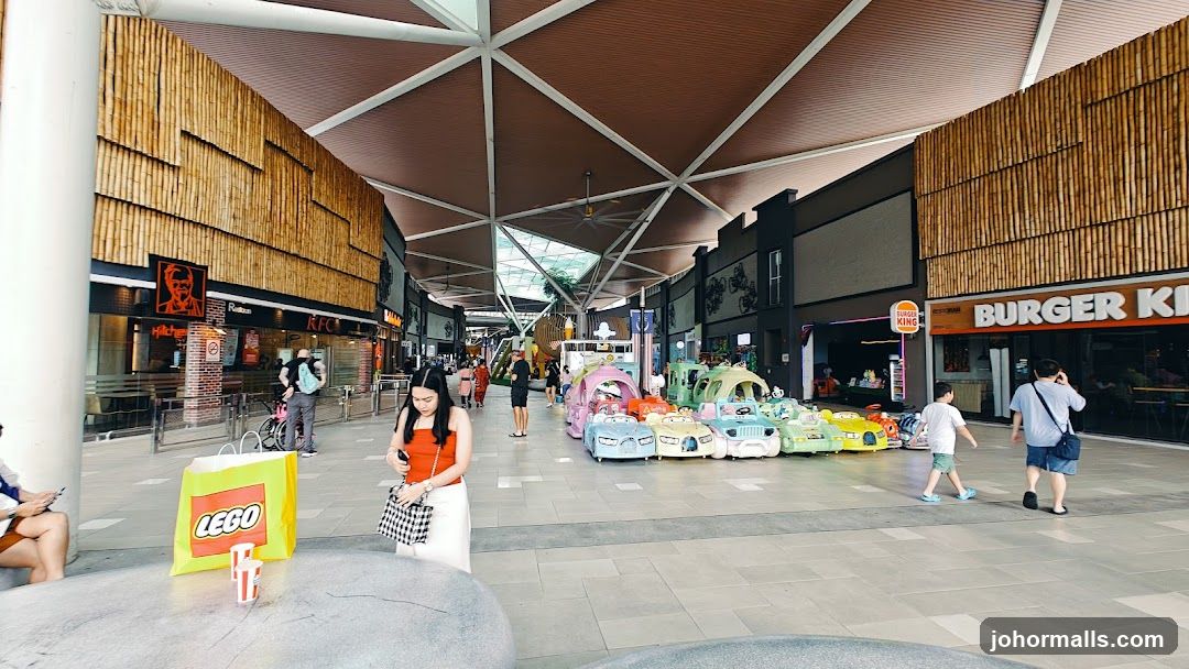 Outdoor shopping arcade with fast food restaurants and children's rides