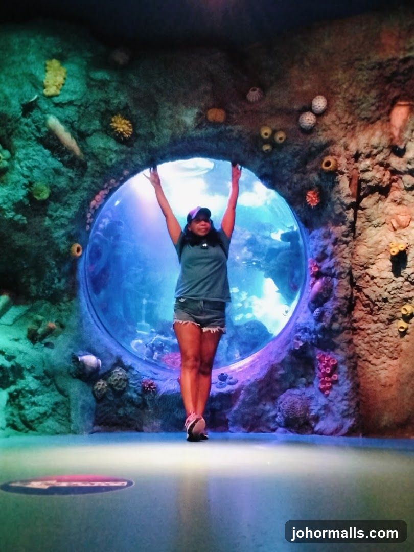 Woman Posing in Front of Aquarium Tunnel