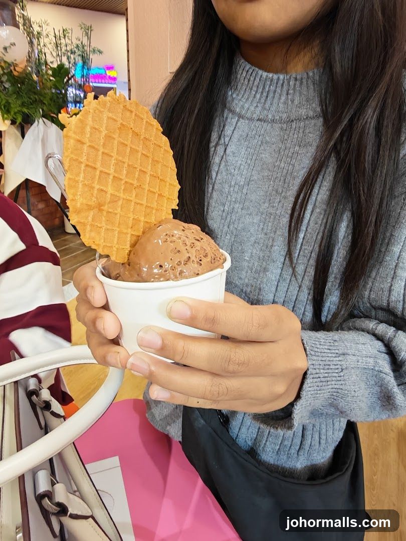 Person holding ice cream with a waffle cone