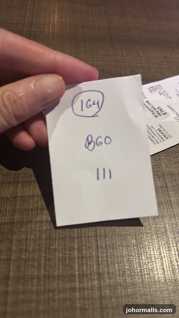 Hand holding a slip of paper with numbers