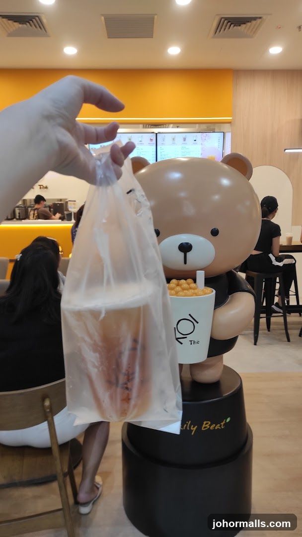 Bear mascot holding a drink