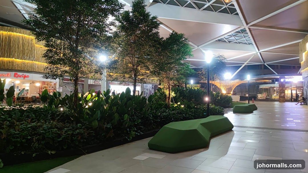 Outdoor mall walkway with greenery and seating
