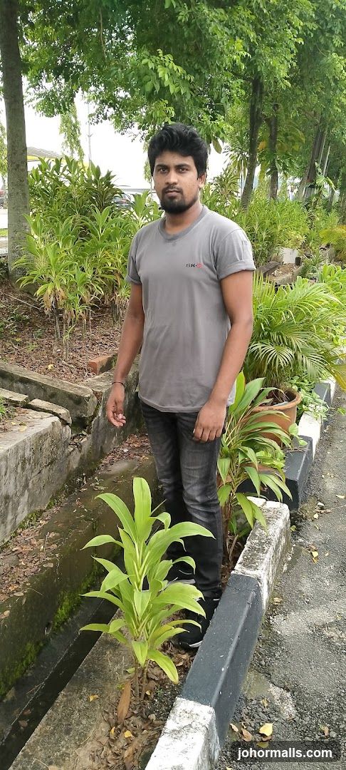 Man in a grey t-shirt and jeans standing outdoors