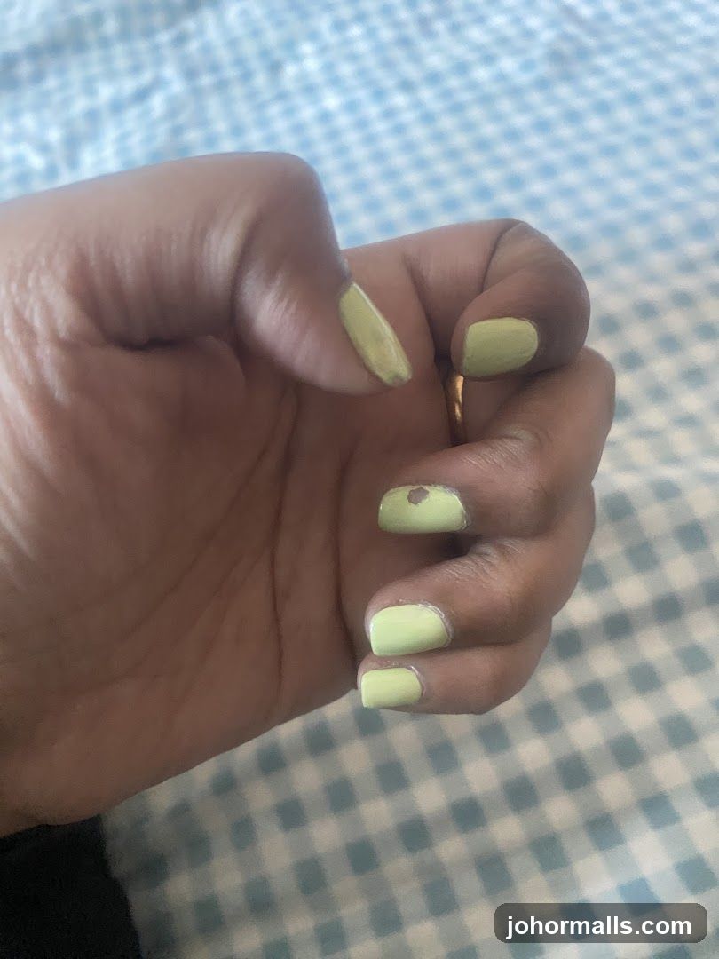 Hand with light green nail polish