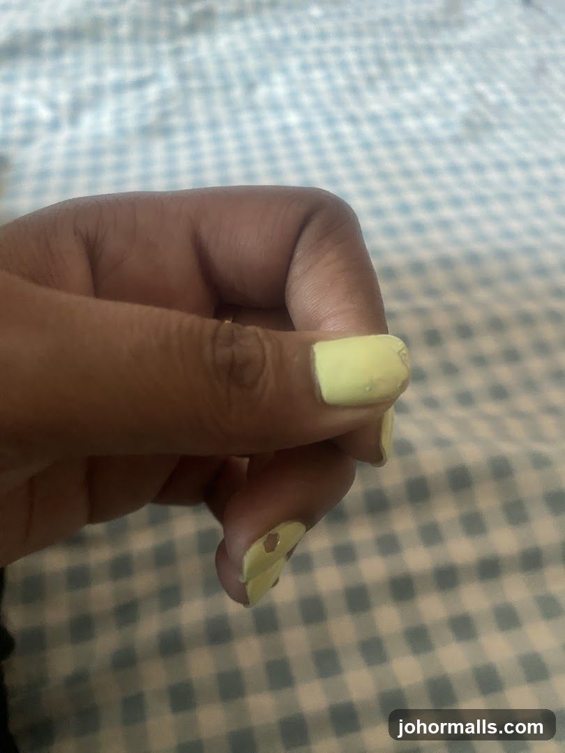 Hand with light yellow nail polish