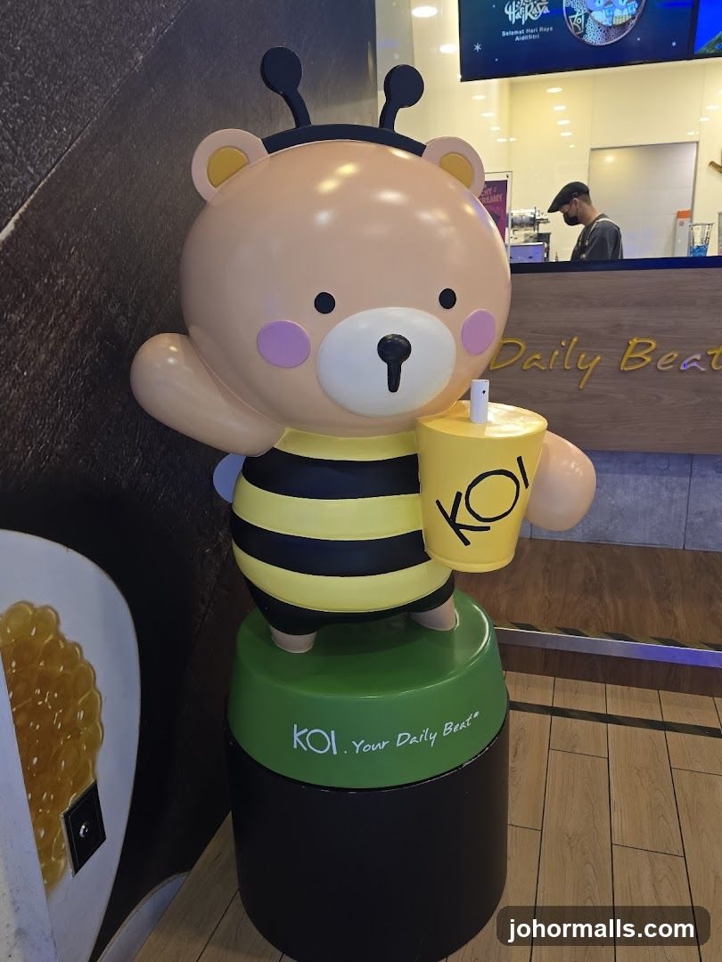 Bear-bee mascot holding a KOI drink