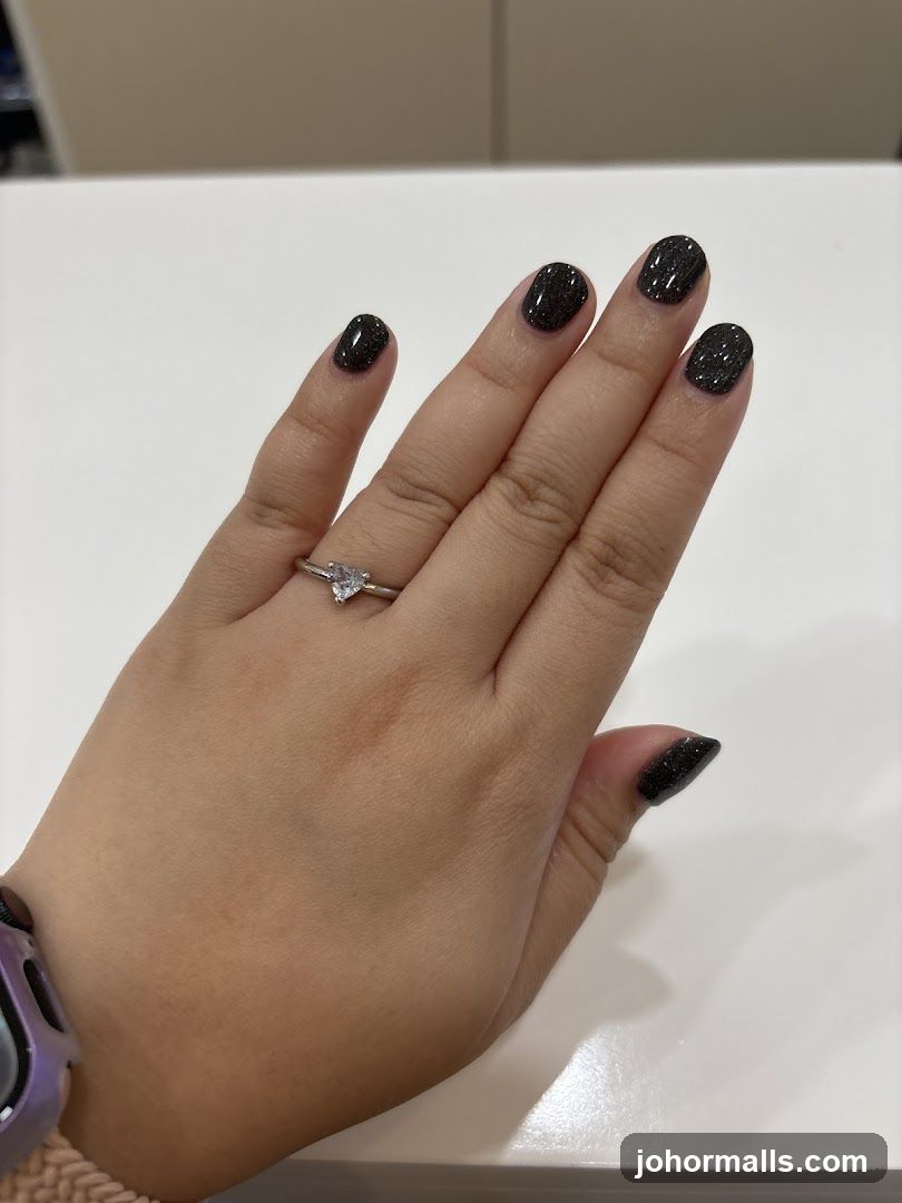 Hand with Ring and Dark Glitter Nails