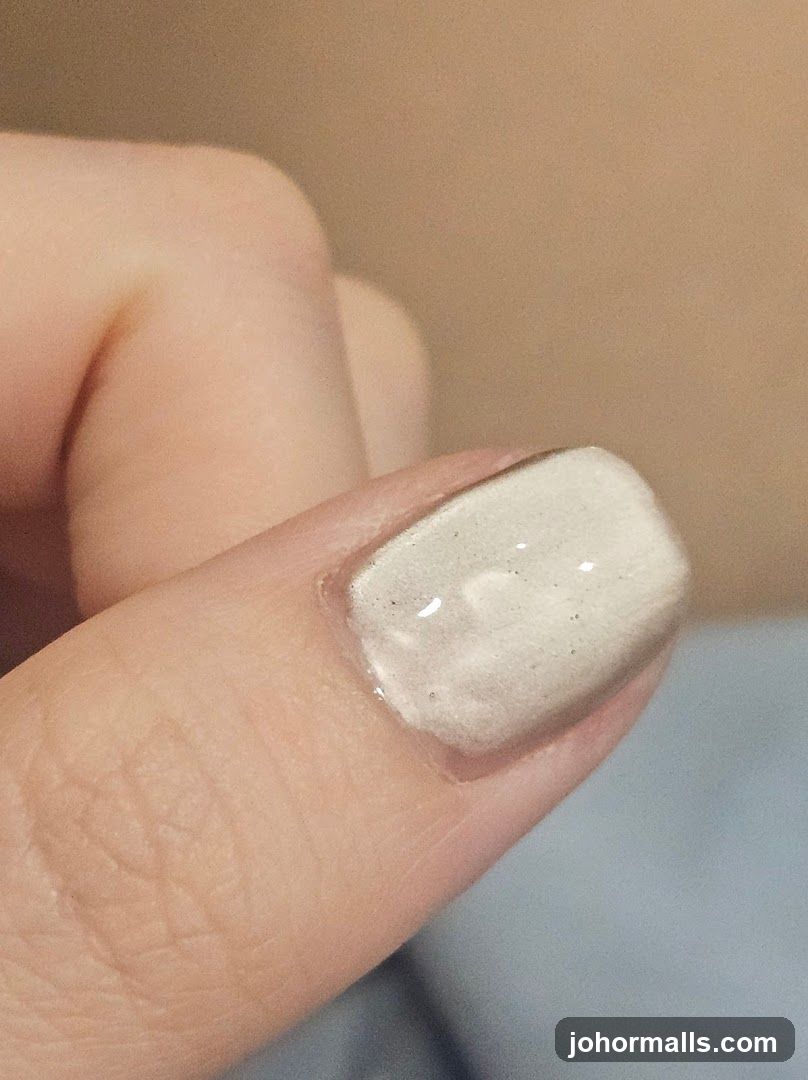 Close-up of a fingernail with light-colored polish