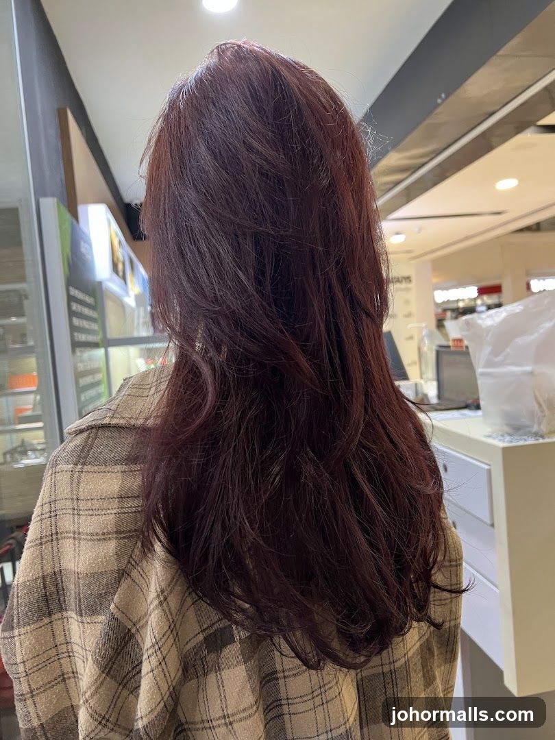 Woman with long, layered, dark red hair