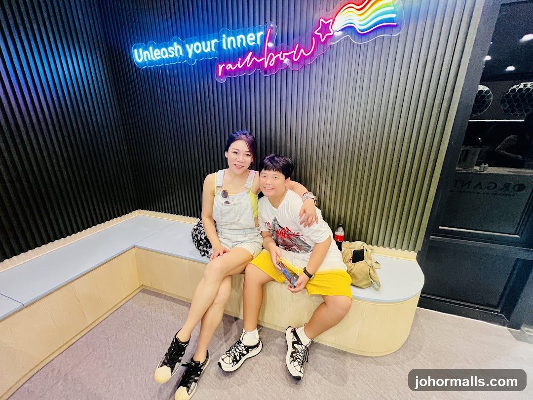 Woman and child posing in front of neon sign